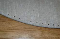 Photo: Detail of shield border with holes for sewing
