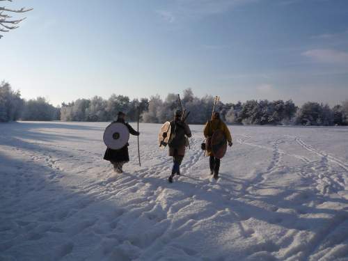Photo: Die Sonne steht noch tief, als sich drei Wikinger mit ihren Rundschilden auf dem Rücken den Weg durch eine verschneite Pläne bahnen.