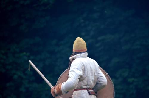 Photo: Das Training hat begonnen und zu Anfang wird Zirkel ohne Ehre gespielt. Das Bild zeigt eine Axtkämpferin von hinten, die in Richtung des unheimlichen, diesigen Waldes schaut.