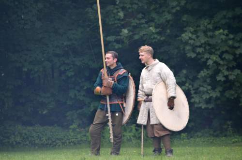 Photo: Beim Teamzirkel-Spiel steht ein Team aus einem Gerkämpfer und einem Spieler mit Einhandaxt und Rundschild am Rand und verfolgt das Geschehen auf dem Feld. Sie beraten sich, bis sie wieder respawnen dürfen. 